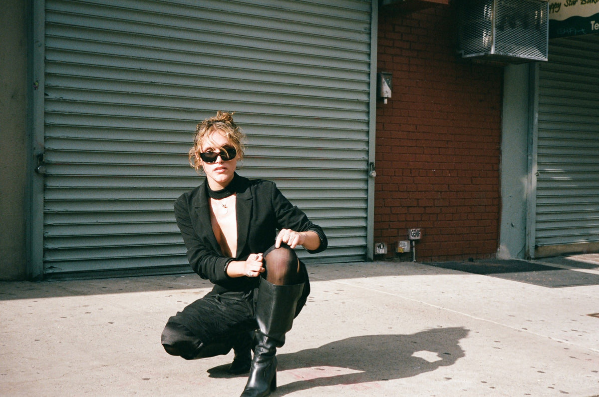 Figure crouched in front of a metal shutter