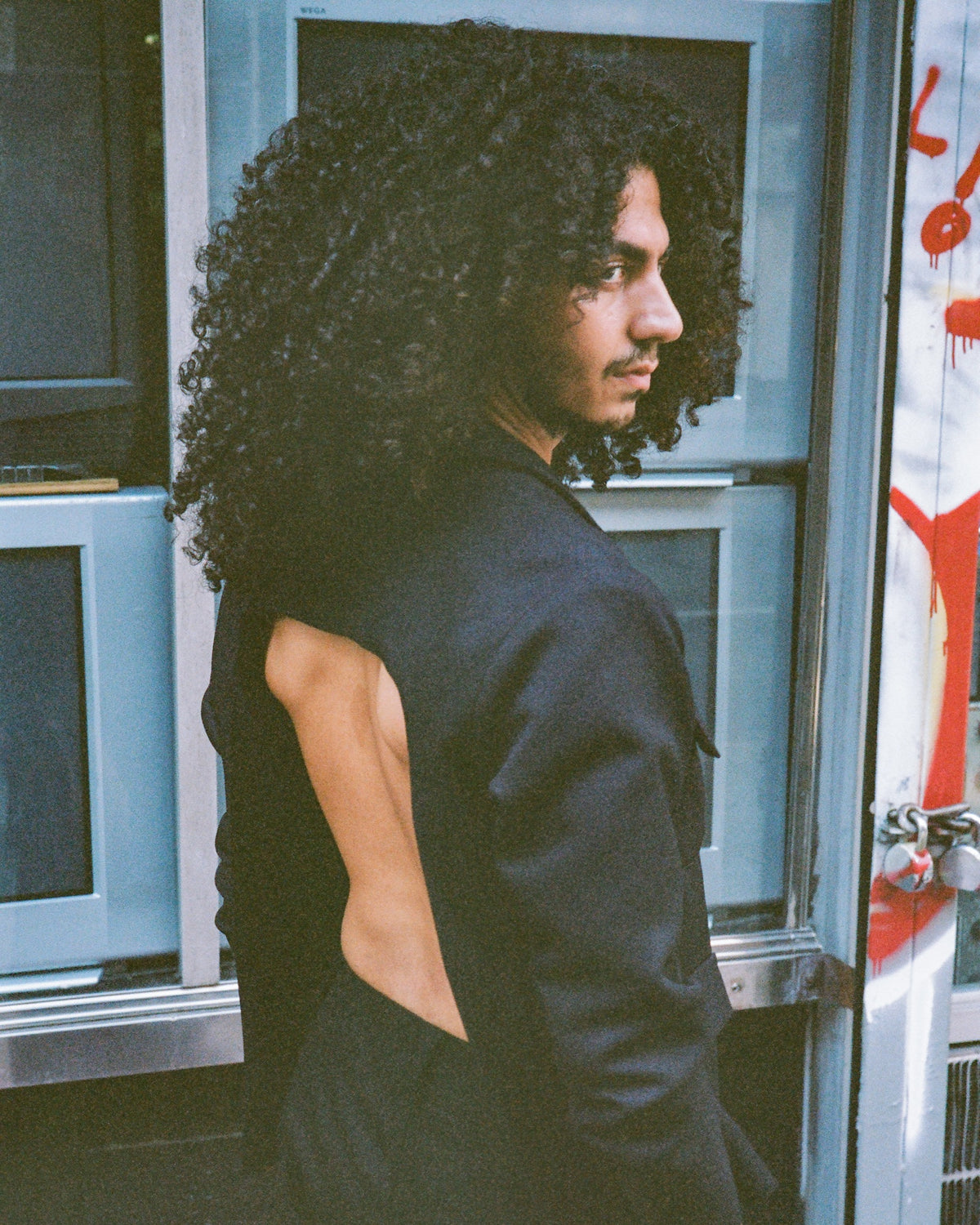 The backless blazer seen from behind in front of a bank of televisions